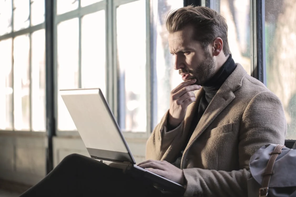 man thinking in front of his laptop